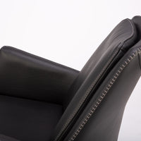 A black leather Kate swivel armchair. Closed up side view.