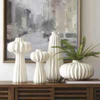 White, hand-crafted Lithos four Vase Collection with irregular ridges that accentuate the three organic shapes.