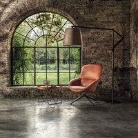 Cloe contemporary Floor Lamp in aged brass, with frame and base in lacquered metal and adjustable arm in lacquered aluminum. Placed in a retro living room.