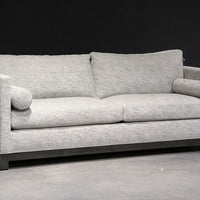 Grey two seat Oscar Sofa that features a slim tuxedo style, foam and down seats, arm bolsters and parson legs. Front and side view.