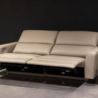 White leather two seat Turin sofa with splayed metal legs and power mechanism that operates the headrest and footrest independently. reclined.