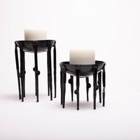 Two black Medieval-inspired iron candleholders.