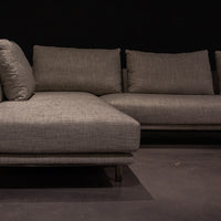 Light grey Quinta Strada Sectional with black chrome finish of the feet, the thinner joining clamps, and light base and back support. Closed up view.