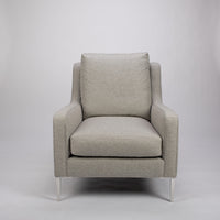 A light grey mid size lounge chair with classic shape and white legs. Front view.