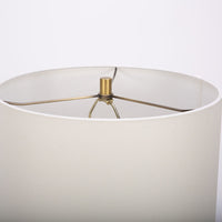 Gavin table lamp with a drum white shade and modern black ceramic body in an unique asymmetric design and a contrasting gold base. Closed up view on the base.