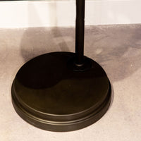 Black Babylon Floor Lamp with formed of bold concentric circles and with floor switch on cord. Closed up view on floor part.