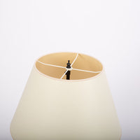 Yul table lamp with cylindrical brass plates applied to create a simple clean, industrial form. Closed up view on the shade.