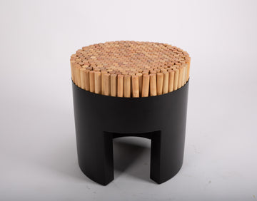 Black Chiquita stool with rigid-looking vertical sections of rattan poles that recede into the seat.