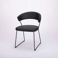 A black leather New York Dining Chair with metal frame and sled base and curved back. Front and side view.