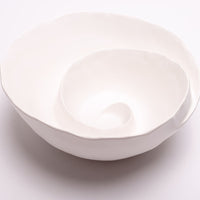 Spiral Bowl made of Portuguese ceramic with an matte white finish and a swirling ridge that spirals from the outer edges of the bowl towards the center.