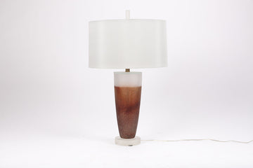 Two-toned Caledonia Table Lamp with an urn shaped form on an opaque lucite base and a white shade.
