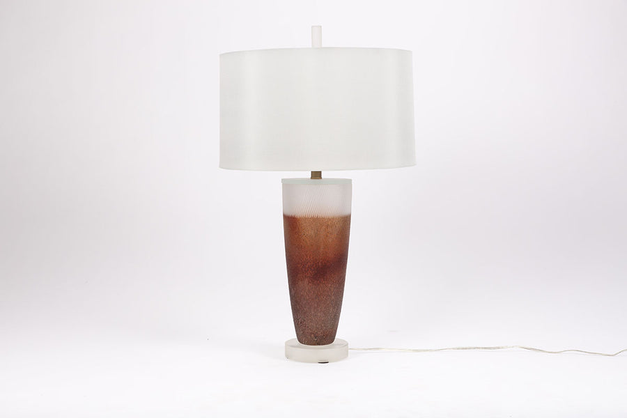 Two-toned Caledonia Table Lamp with an urn shaped form on an opaque lucite base and a white shade.