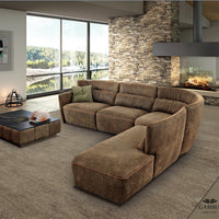 Brown leather Tulip sofa placed in a modern room with a fireplace and visible lake outside the window.