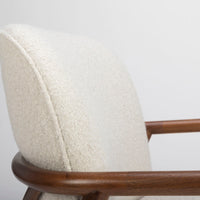 A white Lex lounge chair with solid maple frame, curved back. Closed up side view.