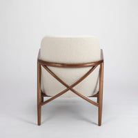 A white Lex lounge chair with solid maple frame, curved back. Back view.