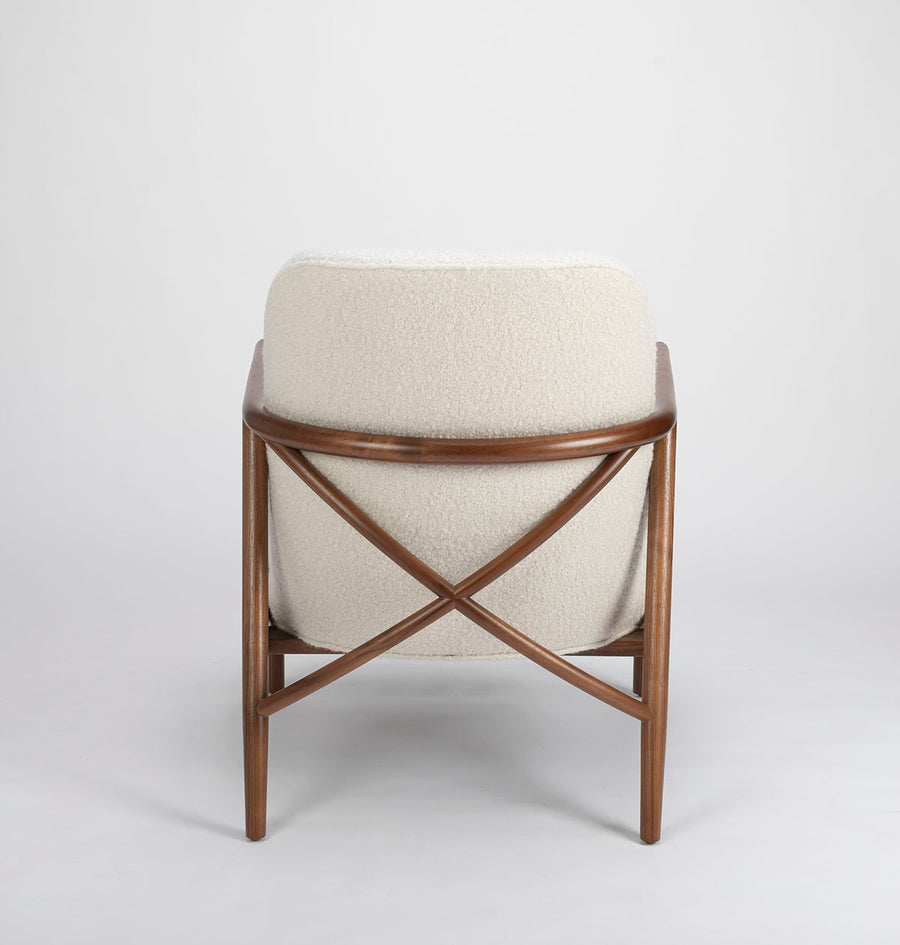 A white Lex lounge chair with solid maple frame, curved back. Back view.