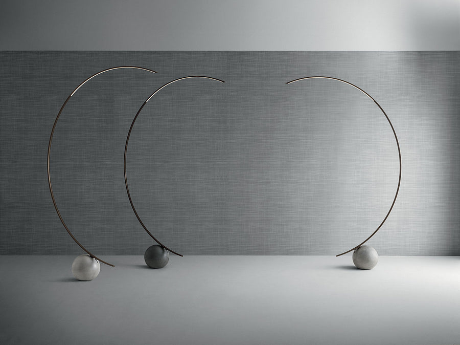 Three elliptical modern Circle metal floor lamp done in dark brass with concrete ball base.