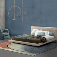 Alfred Nite modern leather bed set up in bedroom with nightstand and blue chair
