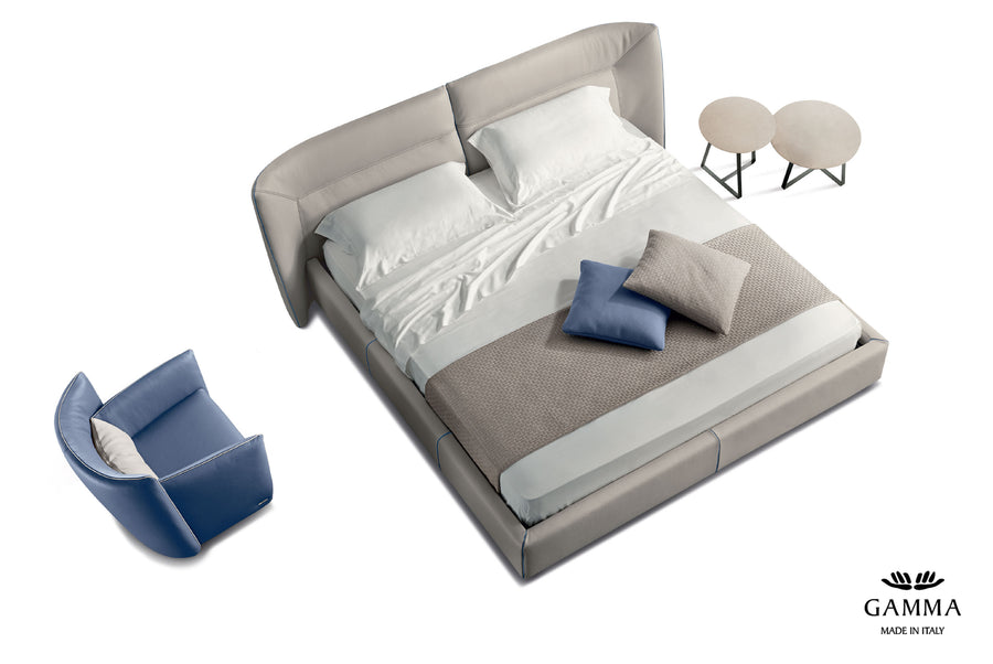 Tulip Leather-upholstered King Size bed in light colors, with bedside tables and a blue chair, a view from above.