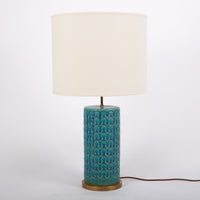 Eliot table lamp with white shade, blue & green wave pattern body with brass accents embellishing the base.