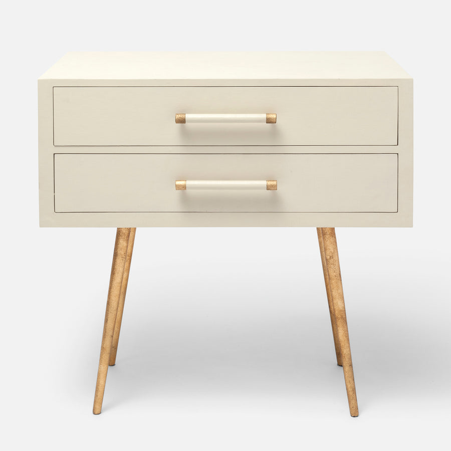 White Alene Nightstand with two drawers and tapered metal legs and handles covered in faux linen with brass hardware detailing.
