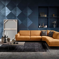 Orange leather Glamour sectional with a special design where the seat and backrest cushions are rested on a linear frame offering a sartorial arm detail. Placed in a modern living room.