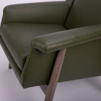 A green lounge chair designed in 1959 by Milo Baughman with solid walnut frame. Closed up side view.