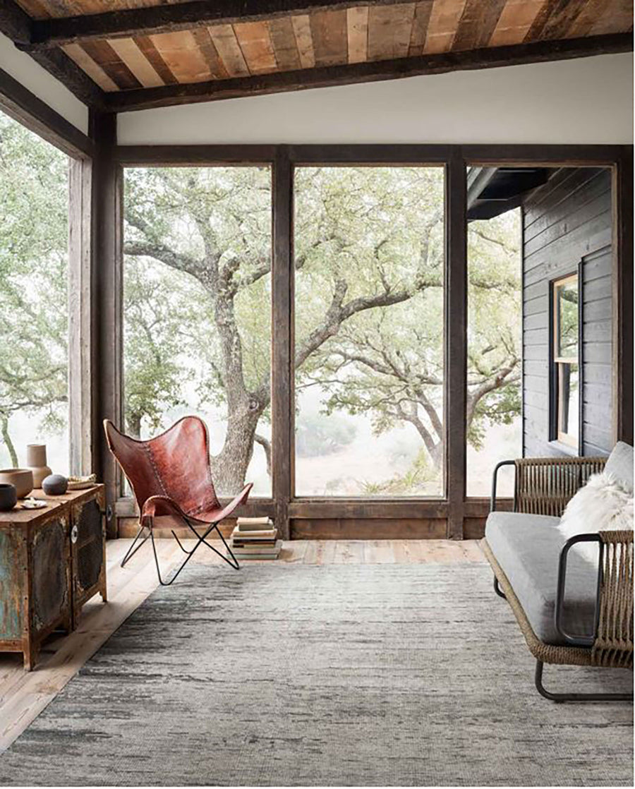 Amara Silver + Dark Grey Area Rug placed on a closed deck with vintage furniture.