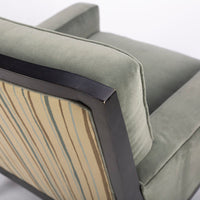 Curtis lounge chair in grey-green color with clean wood detail, softly splayed legs, and outside back framed by the wood trim, closed up top view.