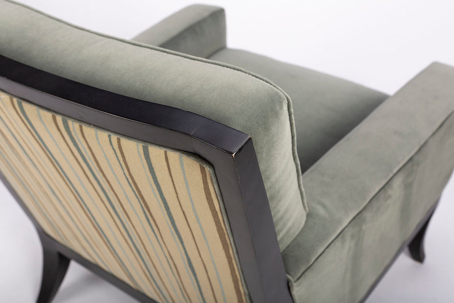 Curtis lounge chair in grey-green color with clean wood detail, softly splayed legs, and outside back framed by the wood trim, closed up top view.