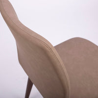 A beige Hexa swivel dining chair with wood base. Closed up top view.