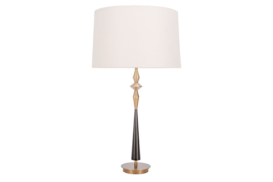 Morrison Lamp with a round Antique Brass base, white drum shade and candlestick silhouette body that combines Antique Brass with Matte Black.