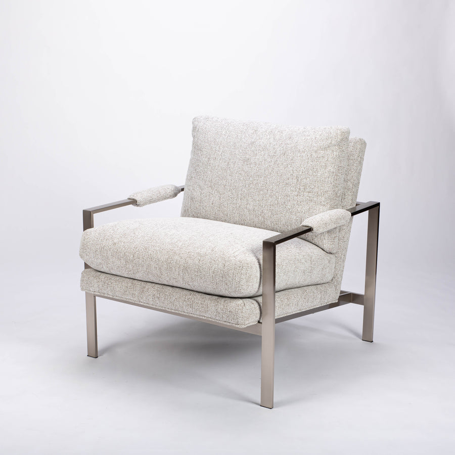951 lounge chair in light colors with slender rectangular steel frame, luxurious blend down seating and upholstery wrapped arm rests, front and side view.