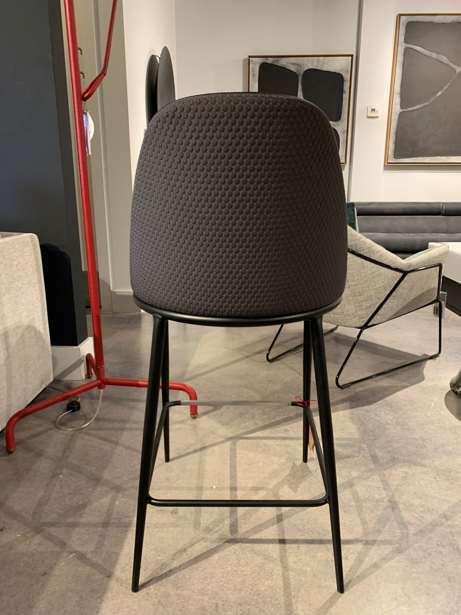 Black Lea counter stool with four-legs metal base and seat and backrest upholstered in hide. Back view.