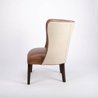 Goodman brown leather chair with curved back, textured woven fabric outside back. Side view.