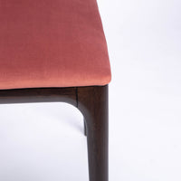 A red four seasons dining chair crafted from solid beechwood. Closed up seat and leg view.
