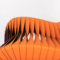 Orange and black Seat Belt dining chair with colorful seatbelt strappings, closed up seat view.