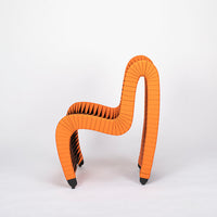 Orange and black Seat Belt dining chair with colorful seatbelt strappings, side view.