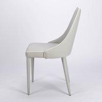 Clara side dining chair completely in white color with curved back tapers and wraps, side view.