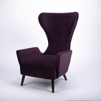 A purple Granta lounge chair with exaggerated curves and period style legs and arms. Front and side view.