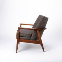 Draper Lounge Chair in midcentury modern classic design with a solid walnut external frame, a steam-bent plywood interior frame and sumptuous tailored upholstery, grey color, side view.