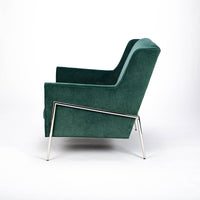 Green fabric Twiggy lounge chair with elegant leg detail in polished steel. Side view.