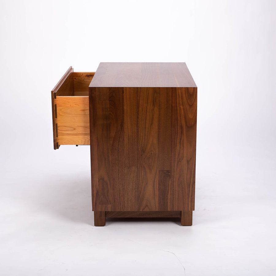 Sloane solid walnut 2 Draw Nightstand. The drawers are constructed of hardwood, dovetailed sides and bottoms and finished in the Green Guard certified finish, side view with open drawer.