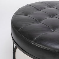 Tufted round ottoman by Cisco Brothers in top navy leather. Closed up view.