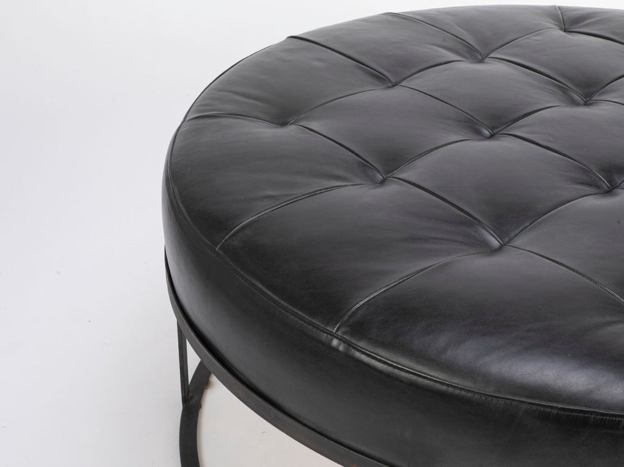 Tufted round ottoman by Cisco Brothers in top navy leather. Closed up view.