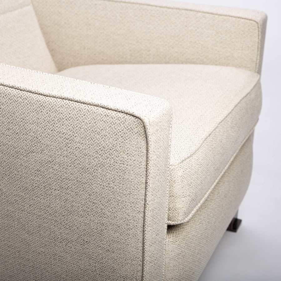 A white fabric Tate recliner lounge chair with stainless steel base, closed up side view.