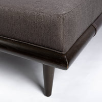 Chatfield Ottoman in Tupelo graphite with a wood base. Closed up view.
