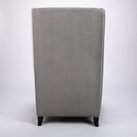 A light grey Rob lounge chair with extra high back, subtle angles and clean shape in the wing detail, back view.