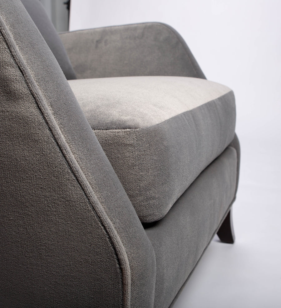 A light grey Rob lounge chair with extra high back, subtle angles and clean shape in the wing detail, closed up bottom view.