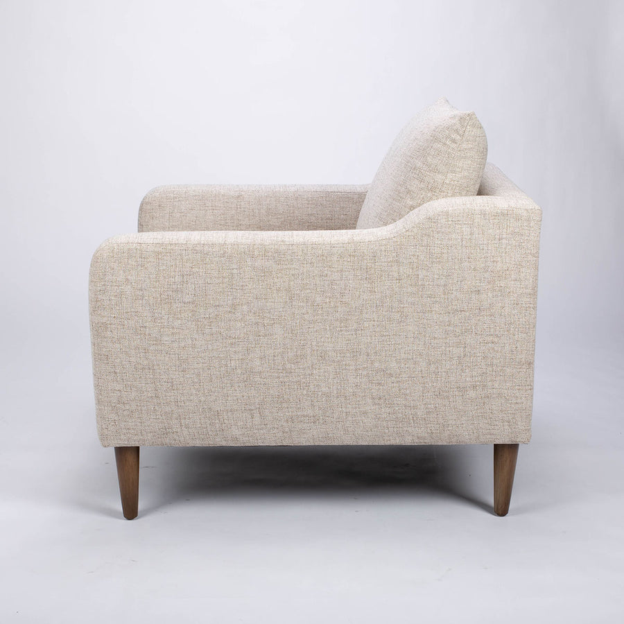 A white fabric Tea lounge stocked chair, side view.